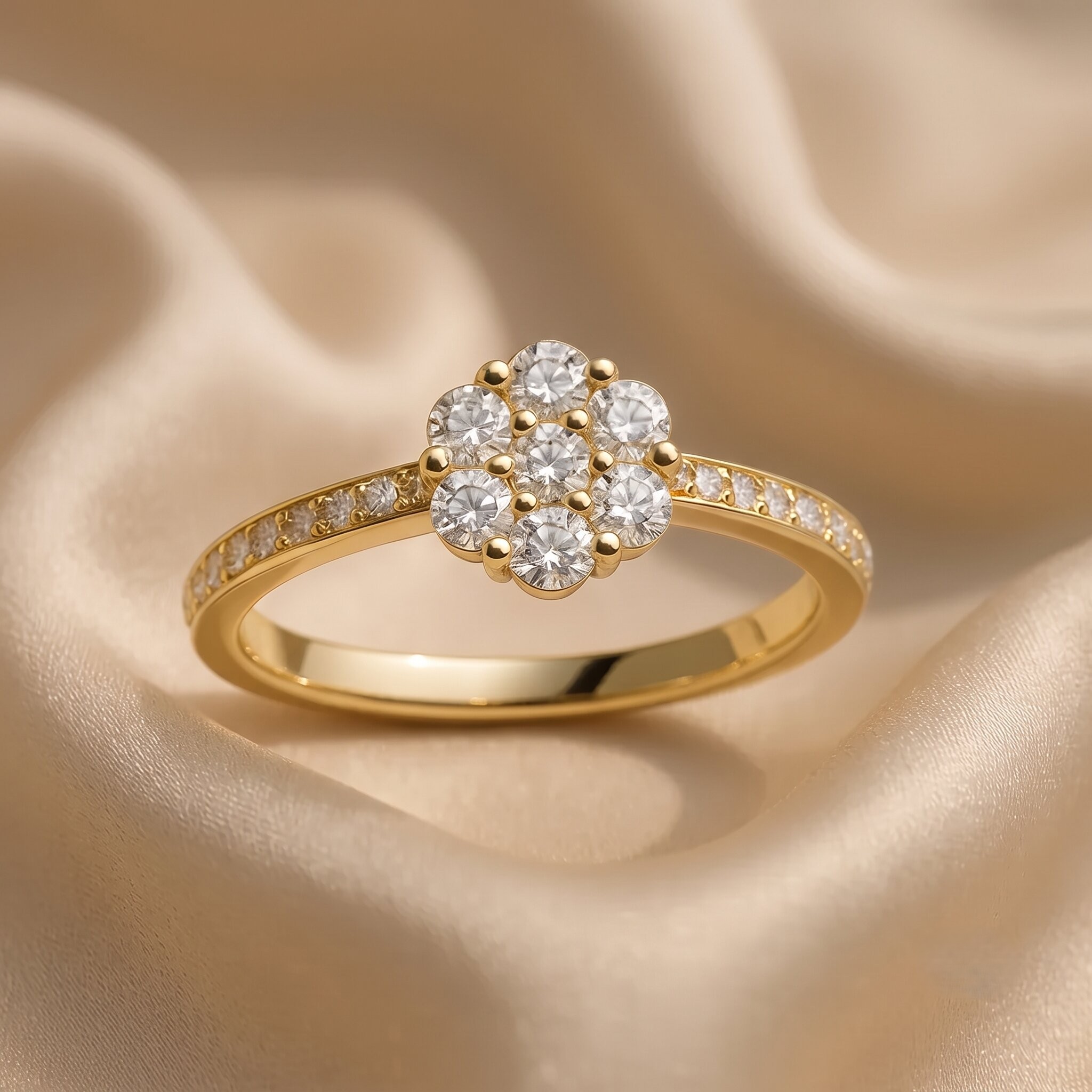 Detaillierte Nahaufnahme eines eleganten Gelbgoldrings mit einem funkelnden Diamanten-Cluster in Blütenform und einem mit Pavé-Diamanten besetzten Band, der auf weichem, champagnerfarbenem Seidenstoff ruht.